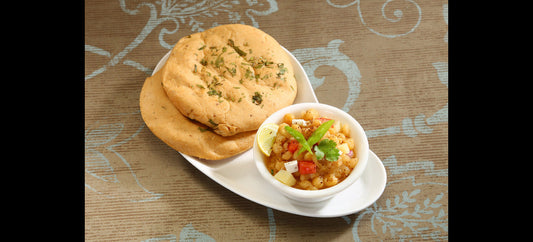 plate of spiced chickpea chole with soft butter-brushed kulchas